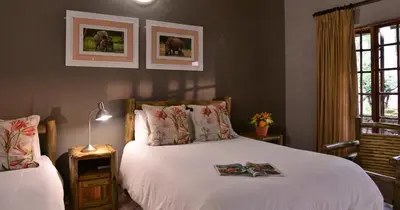 a bedroom with a bed with a book on it at eBundu Lodge in White River