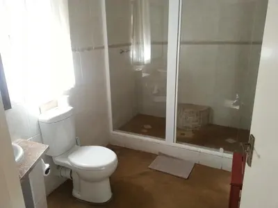 a white bathroom with a toilet and a shower at eBundu Lodge in White River