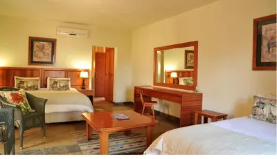 a hotel room with two beds and a mirror at eBundu Lodge in White River