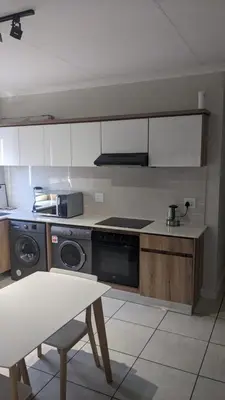 a kitchen with a stove and a table in it at The Blyde 1408 in Pretoria