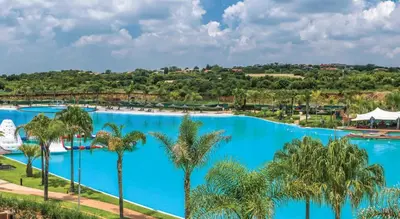 an aerial view of the pool at a resort with palm trees at The Blyde 1408 in Pretoria