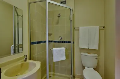 a bathroom with a shower and a toilet and a sink at Road Lodge Centurion in Centurion