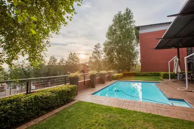 a swimming pool in a yard next to a building at Road Lodge Centurion in Centurion