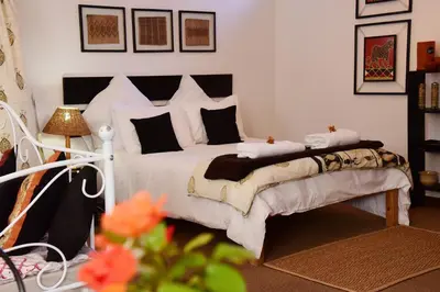 a bedroom with a white bed with black and white pillows at Sebakwe in Dullstroom