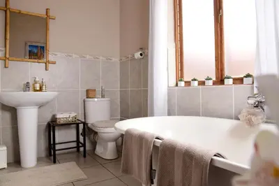 a bathroom with a tub and a toilet and a sink at Sebakwe in Dullstroom