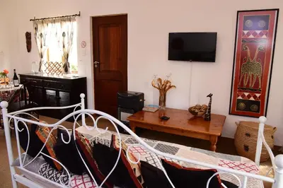 a living room with a bed and a tv at Sebakwe in Dullstroom