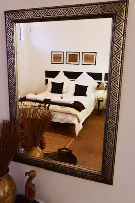 a bedroom with a bed with a large mirror at Sebakwe in Dullstroom