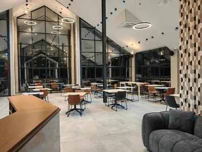 a restaurant with tables and chairs and windows at The Anza Lifestyle Lodge in Louis Trichardt