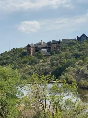 a house on top of a hill next to a river at Reedbuck Lodge @Cyferfontein in Mabalingwe Reserve in Bela-Bela