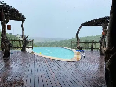 a swimming pool on a wooden deck in the rain at Reedbuck Lodge @Cyferfontein in Mabalingwe Reserve in Bela-Bela