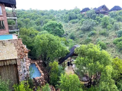 a view of a hill with a house and a river at Reedbuck Lodge @Cyferfontein in Mabalingwe Reserve in Bela-Bela