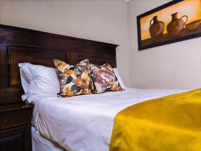a bed with a wooden headboard and a pillow at Lemba Lodge in Dwarsrivier