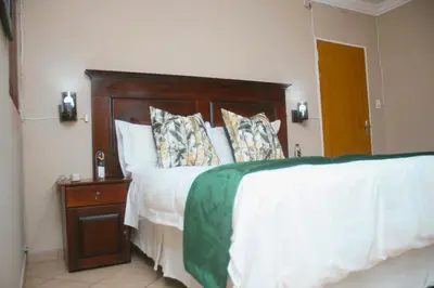 a bedroom with a large bed with a wooden headboard at Lemba Lodge in Dwarsrivier
