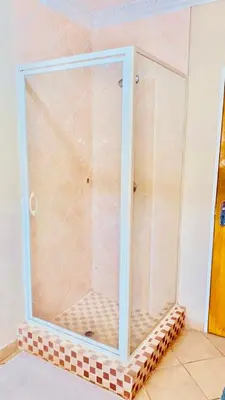 a glass shower in a room with a tiled floor at Lemba Lodge in Dwarsrivier
