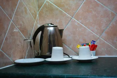 a tea kettle and three cups on a counter at Lemba Lodge in Dwarsrivier