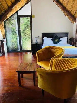 a bedroom with a bed and a chair and a table at GEORGE B BOUTIQUE LODGE in Tzaneen