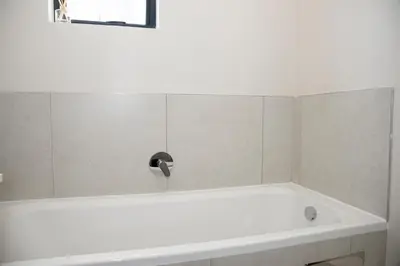 a bath tub with a faucet in a bathroom at Eirini Elegant - Ares Apartment Carlswald in Midrand