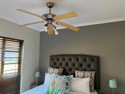 a ceiling fan in a bedroom with a bed at Centurion Ambient Townhouse in Centurion