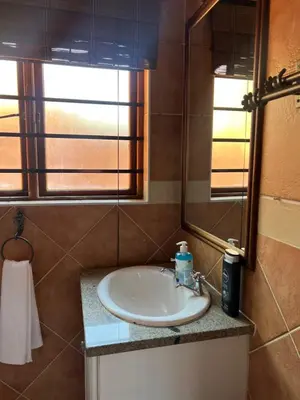 a bathroom with a sink and a mirror at Centurion Ambient Townhouse in Centurion