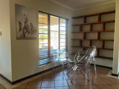 a dining room with chairs and a table and a window at Centurion Ambient Townhouse in Centurion