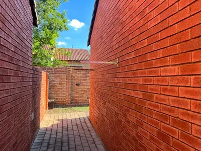a red brick wall with a walkway in front of it at Centurion Ambient Townhouse in Centurion