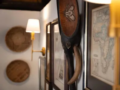 a wooden gun hanging on a wall with a map at KwaMbili Game Lodge in Thornybush Game Reserve