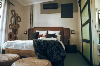 a bedroom with a large bed with a wooden headboard at Arched Farmstead in Eerstegoud