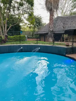 a large blue pool with a water fountain at Arched Farmstead in Eerstegoud