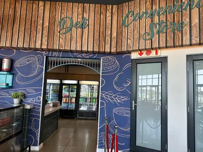 a restaurant with a blue wall with a sign on it at Cosy Waterfall Midrand Apartment in Midrand