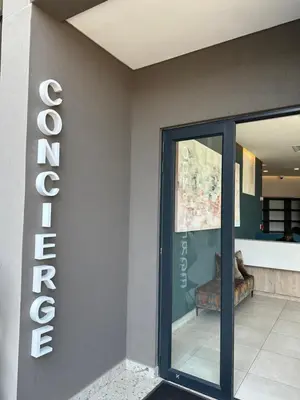 a entrance to a store with a sign on the wall at Cosy Waterfall Midrand Apartment in Midrand