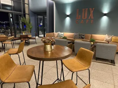 a lobby with a couch and tables and chairs at Cosy Waterfall Midrand Apartment in Midrand