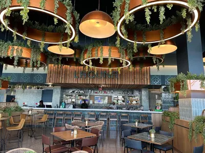 a restaurant with tables and chairs and chandeliers at Cosy Waterfall Midrand Apartment in Midrand