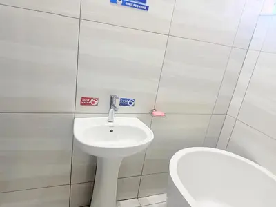 a bathroom with a white sink and a toilet at Silent Night Guest House Sunnyside Pretoria in Pretoria