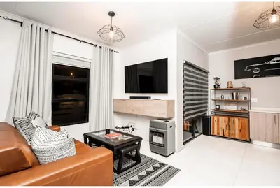 a living room with a couch and a tv at Midrand Classy & Eclectic 1-Bed w/Throwback Vibes in Midrand