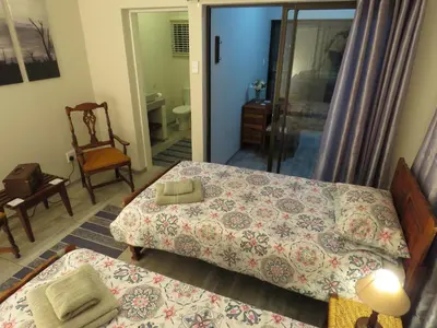 a bedroom with two beds and a chair at Parksig Self Catering in Musina