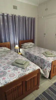 two beds sitting next to each other in a bedroom at Parksig Self Catering in Musina