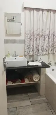 a bathroom with a sink and a tub and a sink at Parksig Self Catering in Musina
