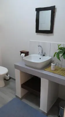 a bathroom with a white sink and a toilet at Parksig Self Catering in Musina