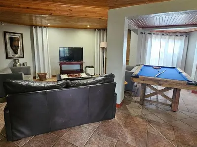 a living room with a couch and a pool table at Grobler's Haven Self catering cottage in Pretoria