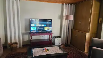 a living room with a television and a coffee table at Grobler's Haven Self catering cottage in Pretoria