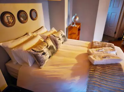 a large bed with pillows on it in a bedroom at Grobler's Haven Self catering cottage in Pretoria