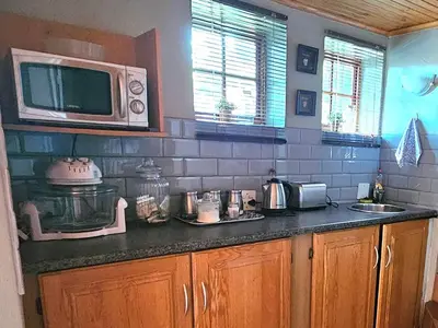 a kitchen with a counter top with a microwave at Grobler's Haven Self catering cottage in Pretoria