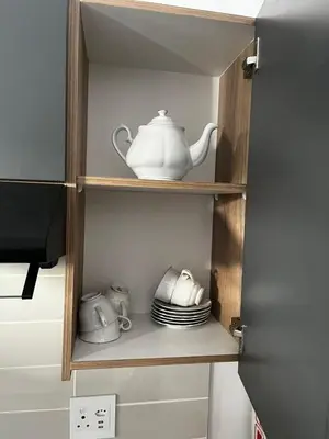 a cupboard with a tea pot and dishes in it at @Bevuzu Creek apartment in Pretoria