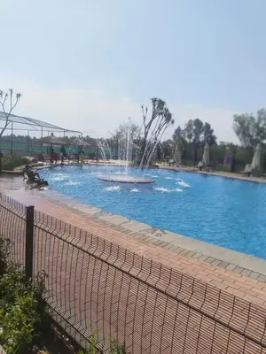 a fountain in the middle of a swimming pool at @Bevuzu Creek apartment in Pretoria