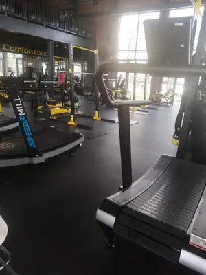 a gym with rows of treadmills and machines at @Bevuzu Creek apartment in Pretoria