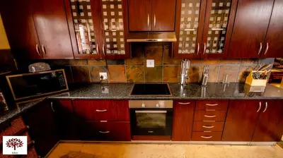 a kitchen with wooden cabinets and a counter top at Zebula Golf and Wildlife Estate - The Milky Way Pax 12 - Moi Signature Luxury villa in Mabula