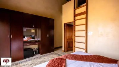 a bedroom with a bed and wooden cabinets at Zebula Golf and Wildlife Estate - The Milky Way Pax 12 - Moi Signature Luxury villa in Mabula
