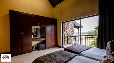 a bedroom with a bed and a large window at Zebula Golf and Wildlife Estate - The Milky Way Pax 12 - Moi Signature Luxury villa in Mabula