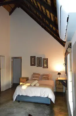 a bedroom with a bed with pillows on it at Elijara Kruger Lodge in Marloth Park