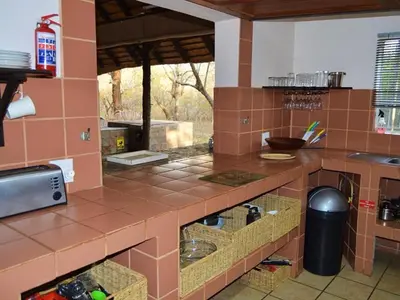 a large kitchen with brown tiles on the counters at Elijara Kruger Lodge in Marloth Park